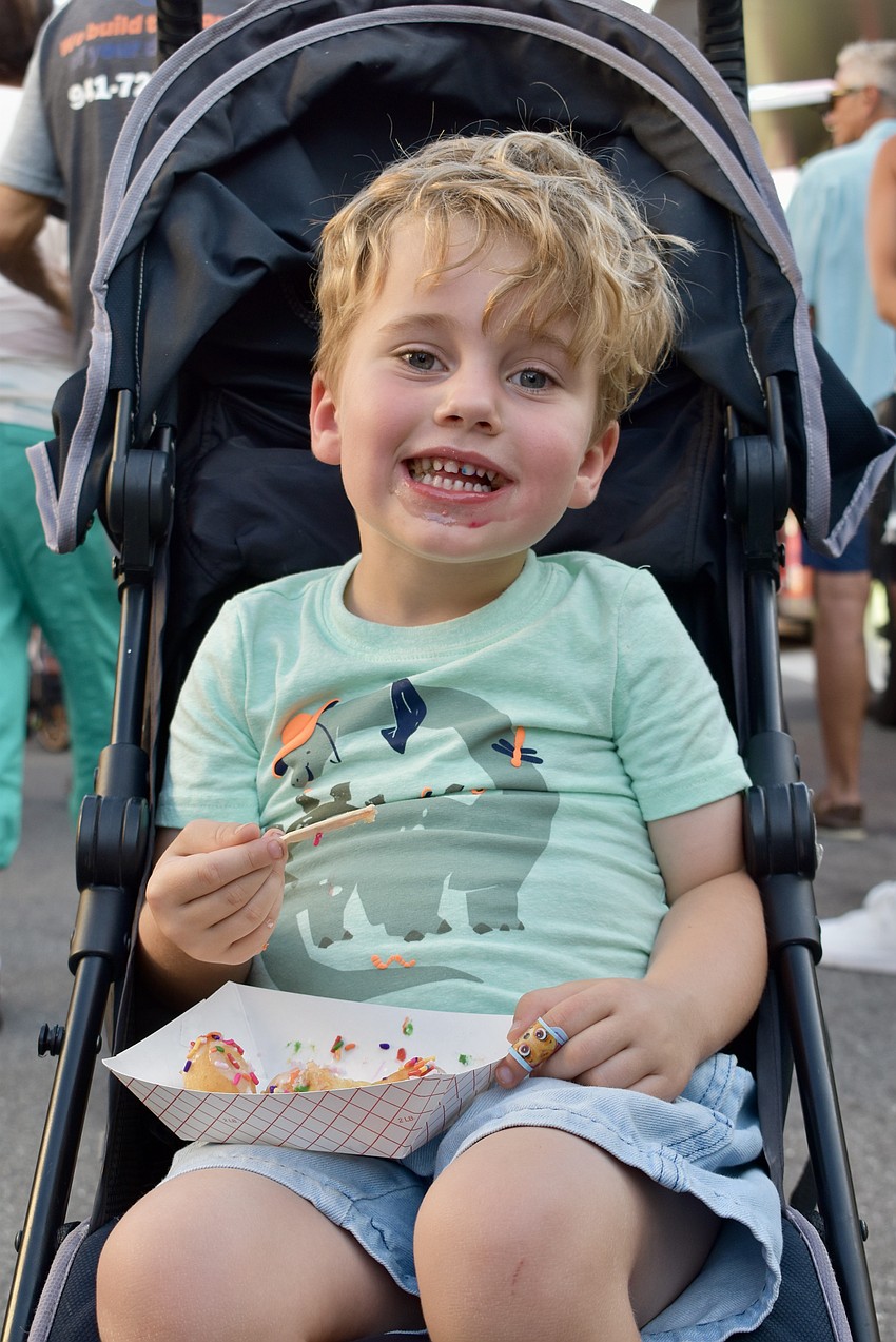 Sarasota resident Grayson Brown, 4, enjoys mini donuts from the Better by the Dozen truck.