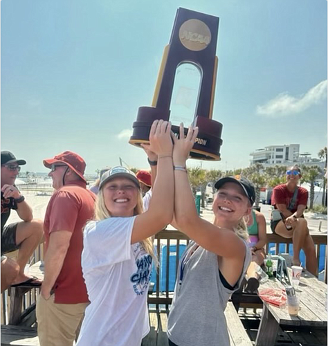 Sisters Ashley Pater and Brooke Pater hold up Ashley's NCAA Division I beach volleyball title, which she won as a freshman at the University of Southern California. Both sisters won national championships in 2024.