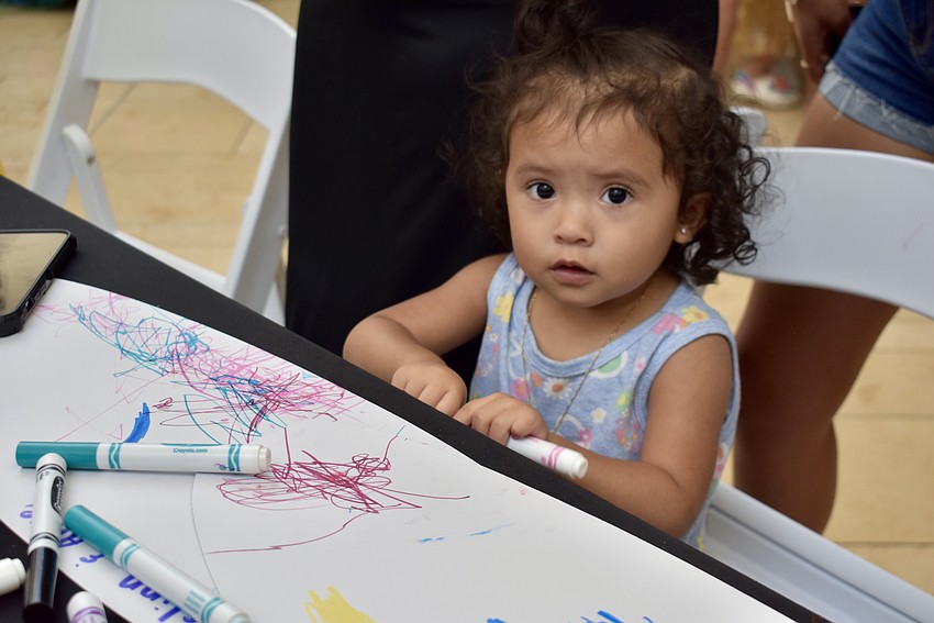 Bradenton resident and 1-year-old Alice Rodriguez colors a surfboard.