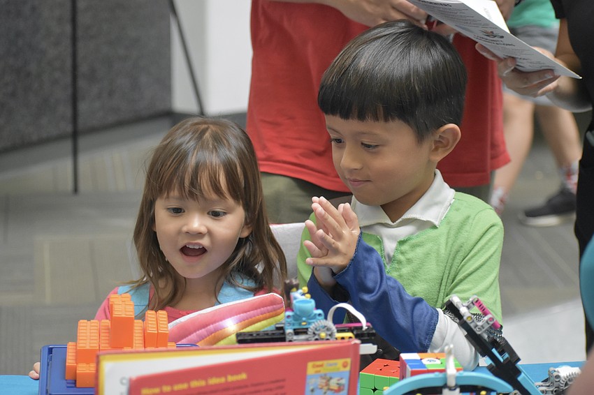 Leander How, 3, and Artemis Howe, 6, play with a Lego earthquake shake table.