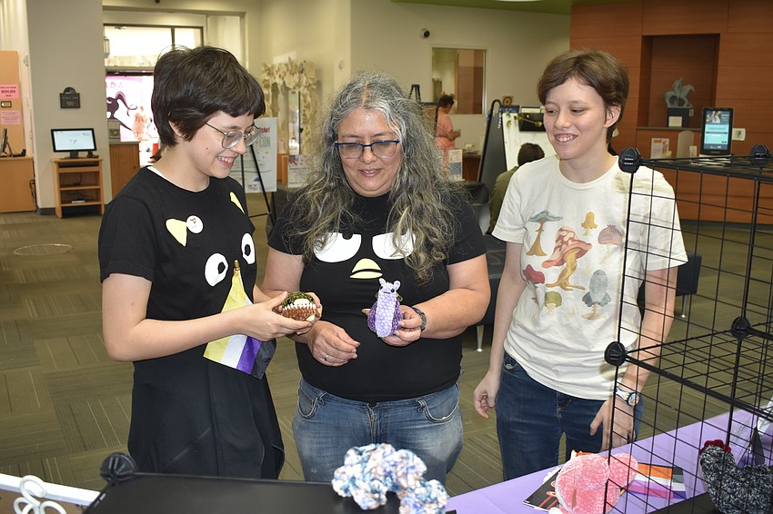 Helena Kushner, 13, Nova Myhill and Ursula Kushner look at the crochet items by Zarhya Jurado
