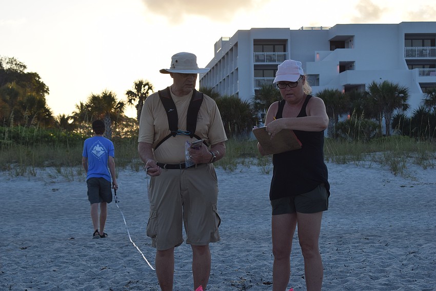 Sam DiGiammarino and Brenda Jameson filled out information on their newly marked turtle nest.