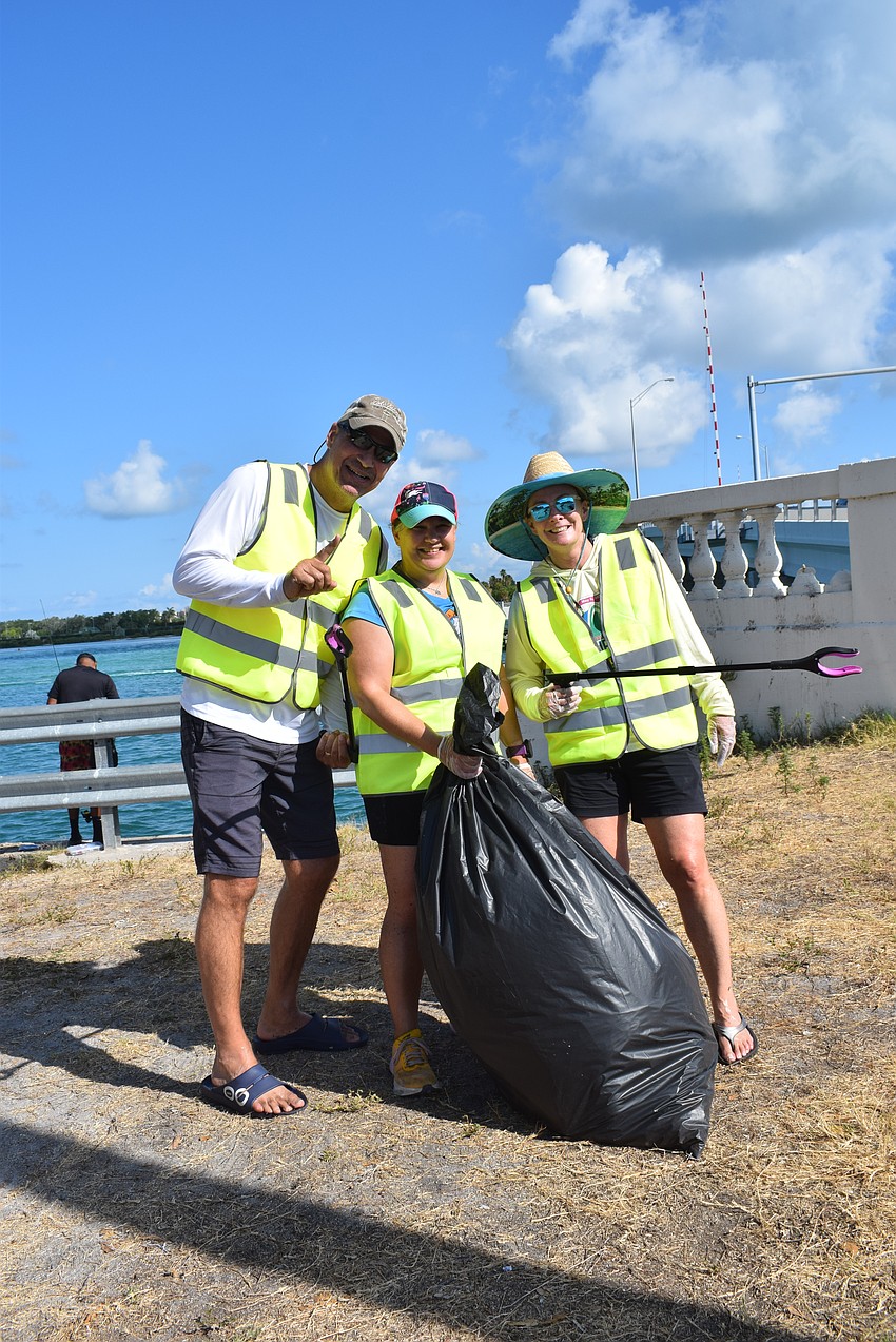 Jason Richards, Angie Long and Lori Richards with a full bag of trash.