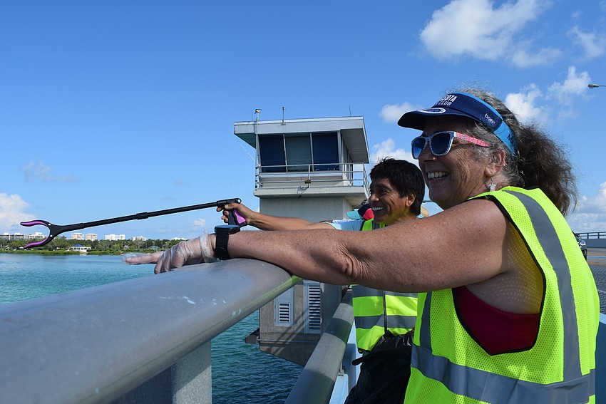 Andre Hidalgo and Kelly Anderson spot dolphins in Sarasota Bay while picking up trash over the bridge.