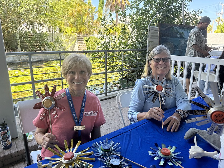 Volunteers for Mote's home school program Jeanne Panka and Melanie Babineau present flowers made from recycled cans.