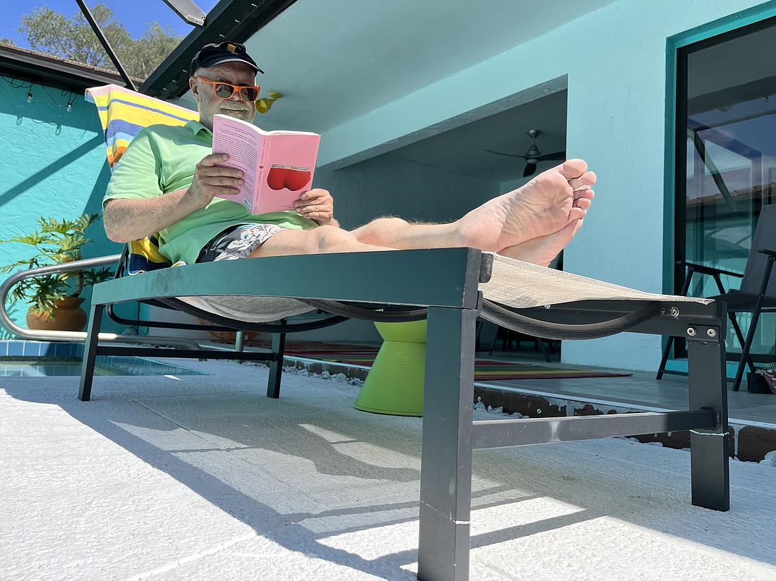 Robert Plunket relaxes poolside in the Glen Oaks neighborhood of Sarasota, perusing what he hopes will be a summer best-seller.