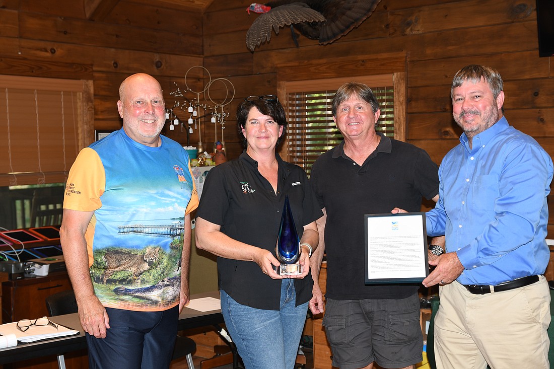 Nathalie Visscher, second from left, was honored with the Jim Thomas Environmental Hero Award at the June 4 Friends of Lake Apopka meeting. Presenting the award are Joe Dunn, left, FOLA executive director; Jim Peterson, Ocklawaha River Basin coordinator for the St. Johns River Water Management District; and Steve Koontz, FOLA president.