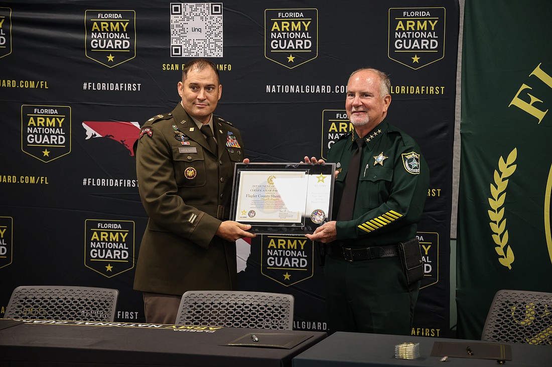 MAJ William Wiseman and Sheriff Rick Staly pose with a plaque presented during the U.S. Army PaYS Program Signing Ceremony. Courtesy of the FCSO