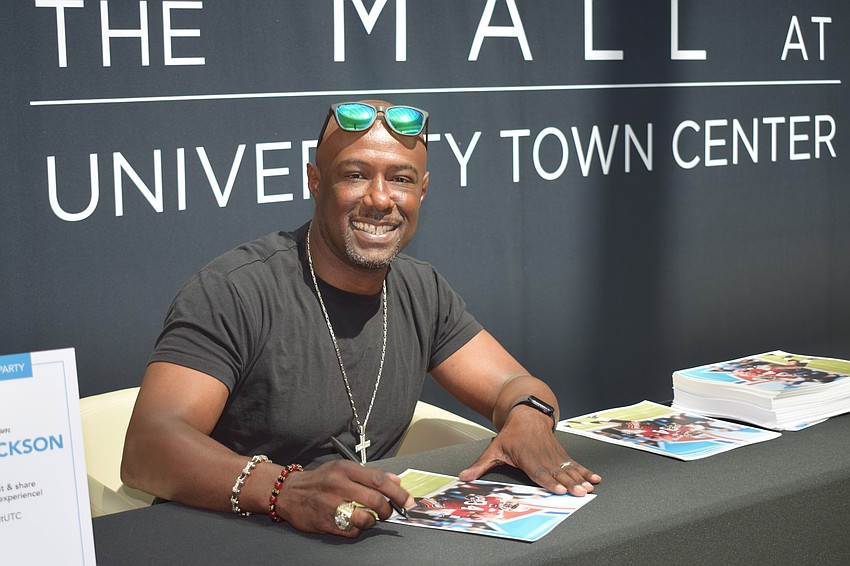 Dexter Jackson, a former safety for the Tampa Bay Buccaneers, signs autographs at Dad's Day Block Party.