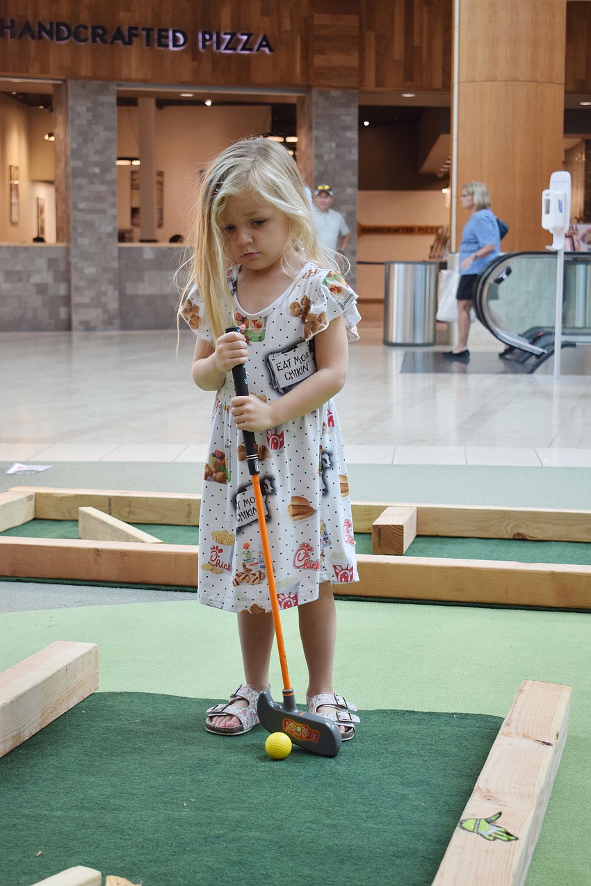 Sarasota 4-year-old Emberley Allen has fun playing mini golf.