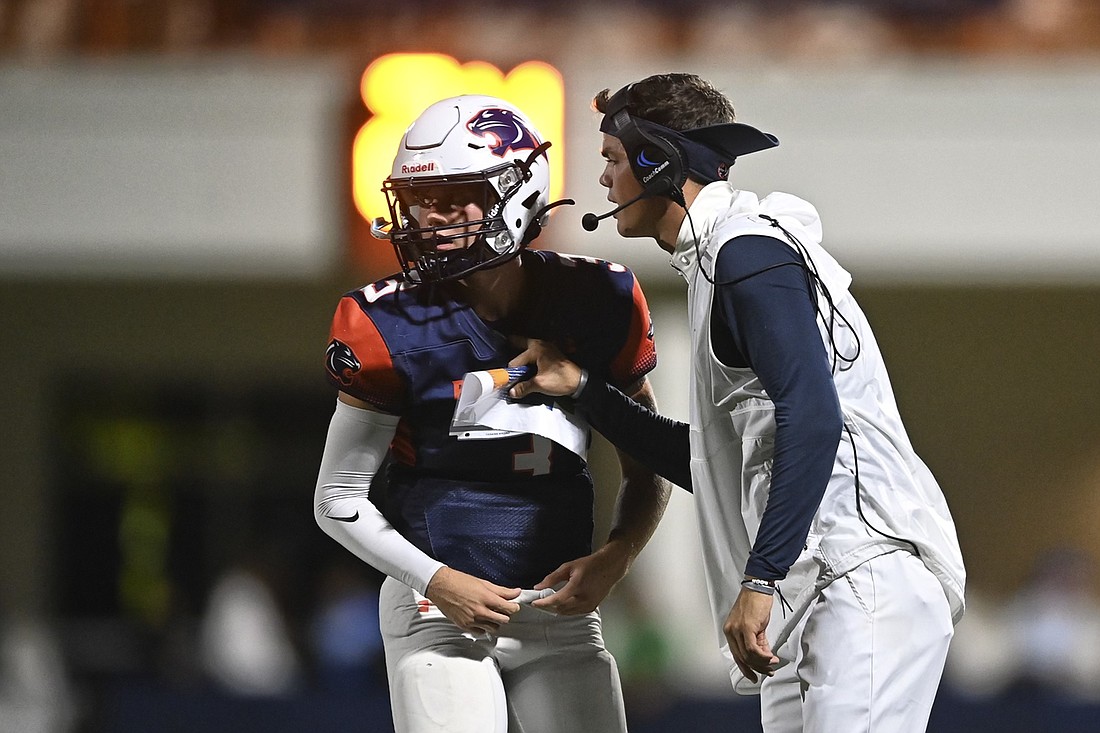 Nate Strawderman (right) gives instructions to Bradenton Christian quarterback Caden Ott. Strawderman is going The Out-of-Door Academy football program as an associate head coach and passing game coordinator. He will also be an assistant athletic director at the school.