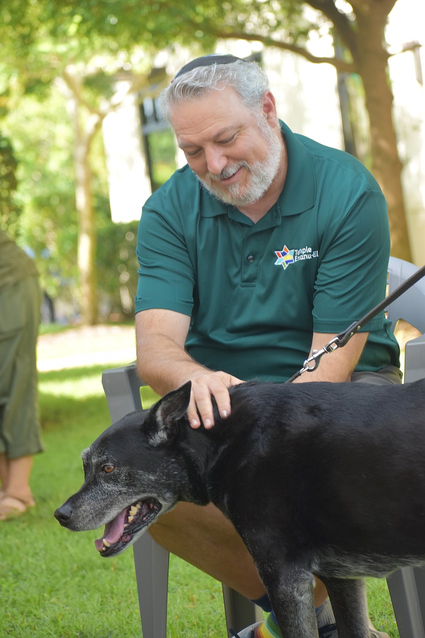 Rabbi Michael Shefrin pets Shadow, who belongs to Martin and Gail Grusin