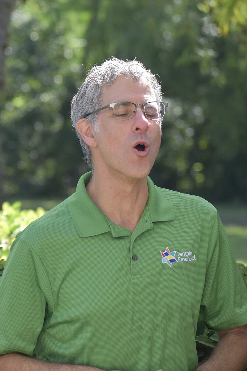 Rabbi Brenner Glickman helps Rabbi Michael Shefrin offer a special message to the dogs, in their own language.