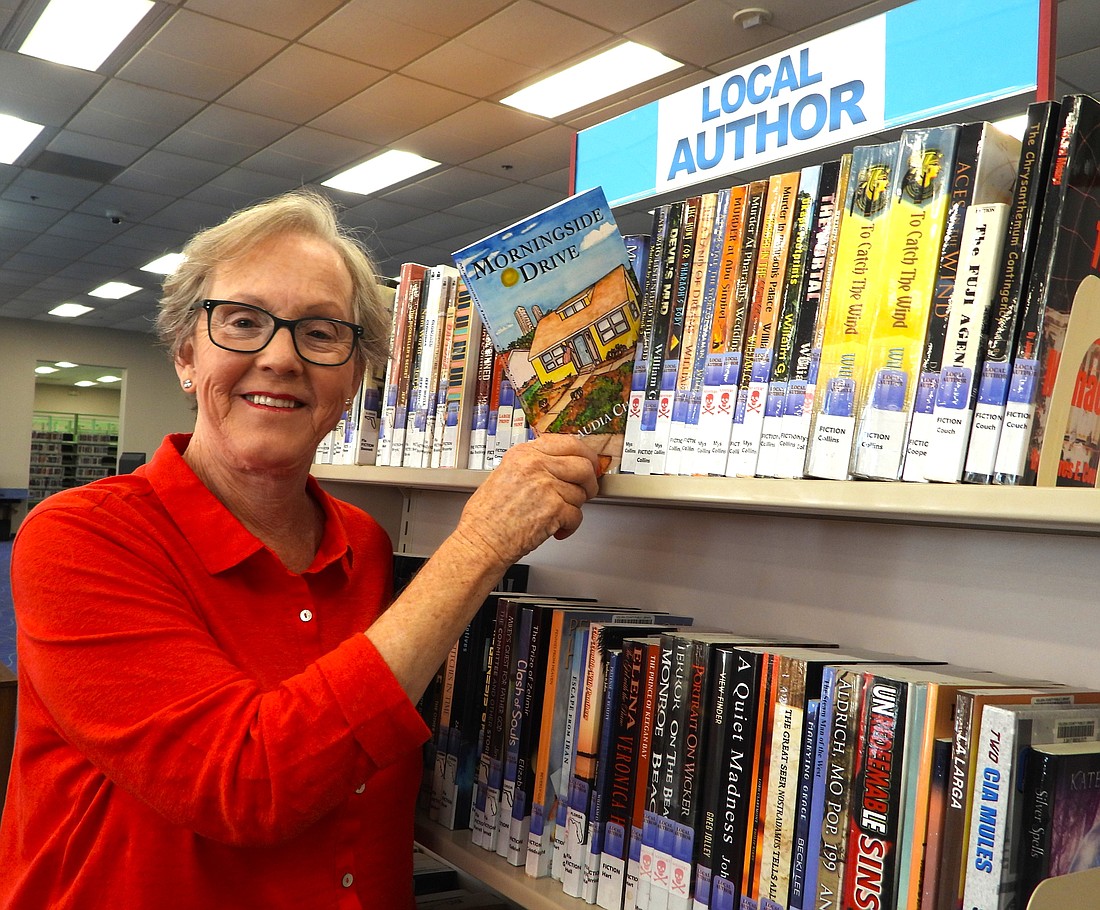 Author Claudia Chianese places her debut novel on a shelf featuring local authors at the Ormond Beach Regional Library.Photo courtesy of Cindy Casey/CCE Publishing