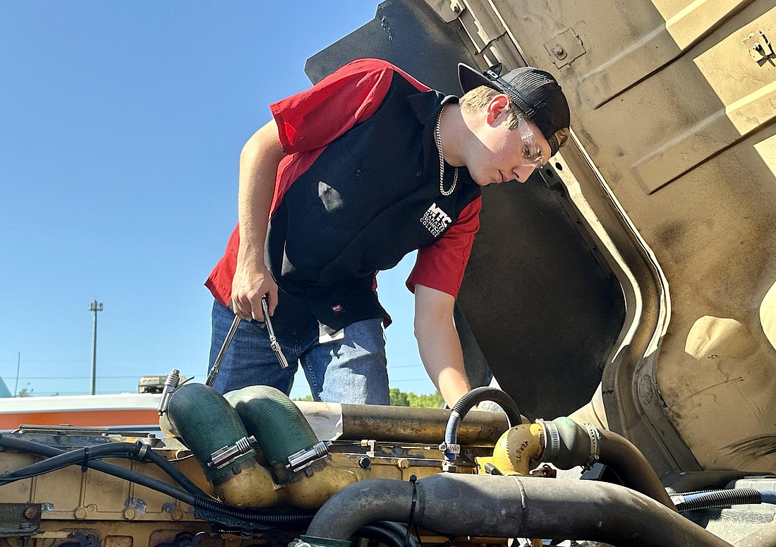 Alec Henderson, a recent graduate of the diesel systems program at Manatee Technical College, looks over a truck engine. He's already had been offered a job at Ring Power, a local construction machinery dealer.