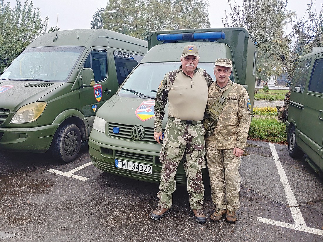 Attorney Phillip Buhler, left, with a member of the Ukraine Territorial Defense Force and one of the many ambulances Buhler helped deliver to the Eastern European country.