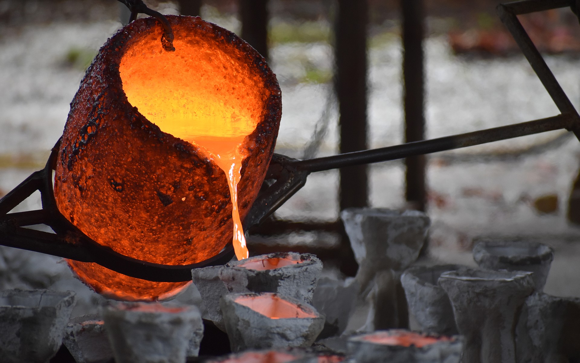 Molten bronze is poured from the crucible into a series of molds at Bronzart Foundry.
