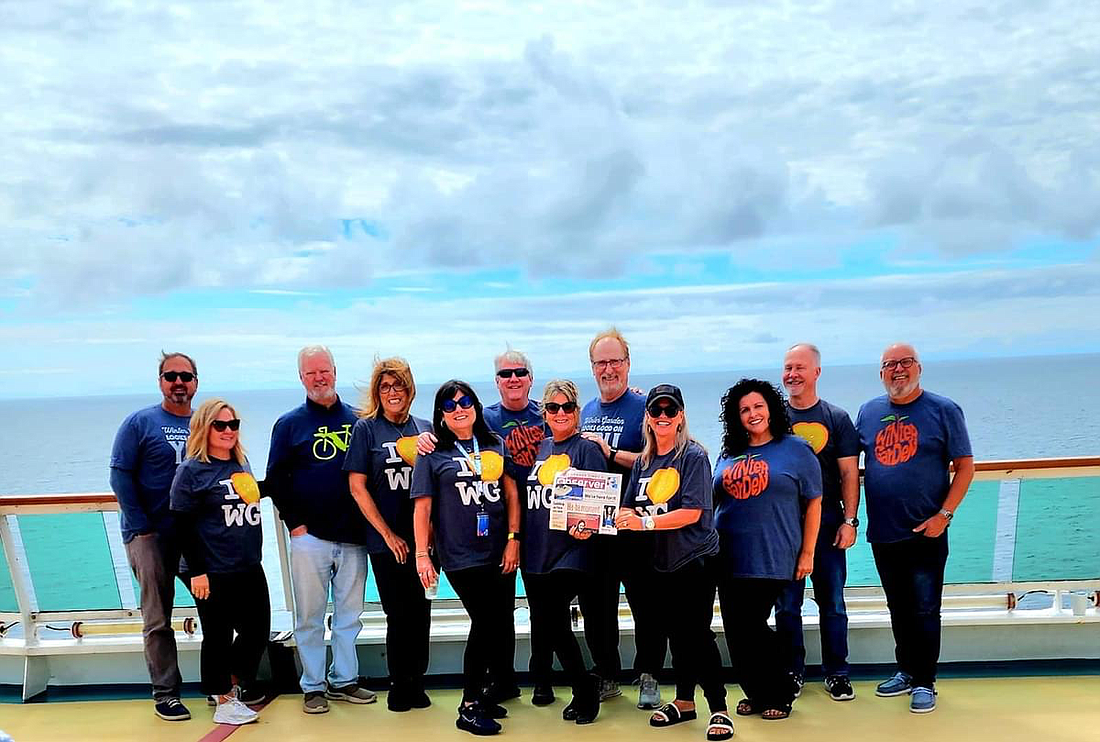 A group of friends took their local newspaper when they cruised from Vancouver, British Columbia, Canada, to Anchorage, Alaska: Chris Lee, left, Dania Lee, Ron Sikes, Laura Sikes, Robin Parker, Daryll Parker, Jennifer Talbot, Rod Talbot, Samantha Robinson, Diana Rinaldi, Fred Chambers and Dennis Robinson.