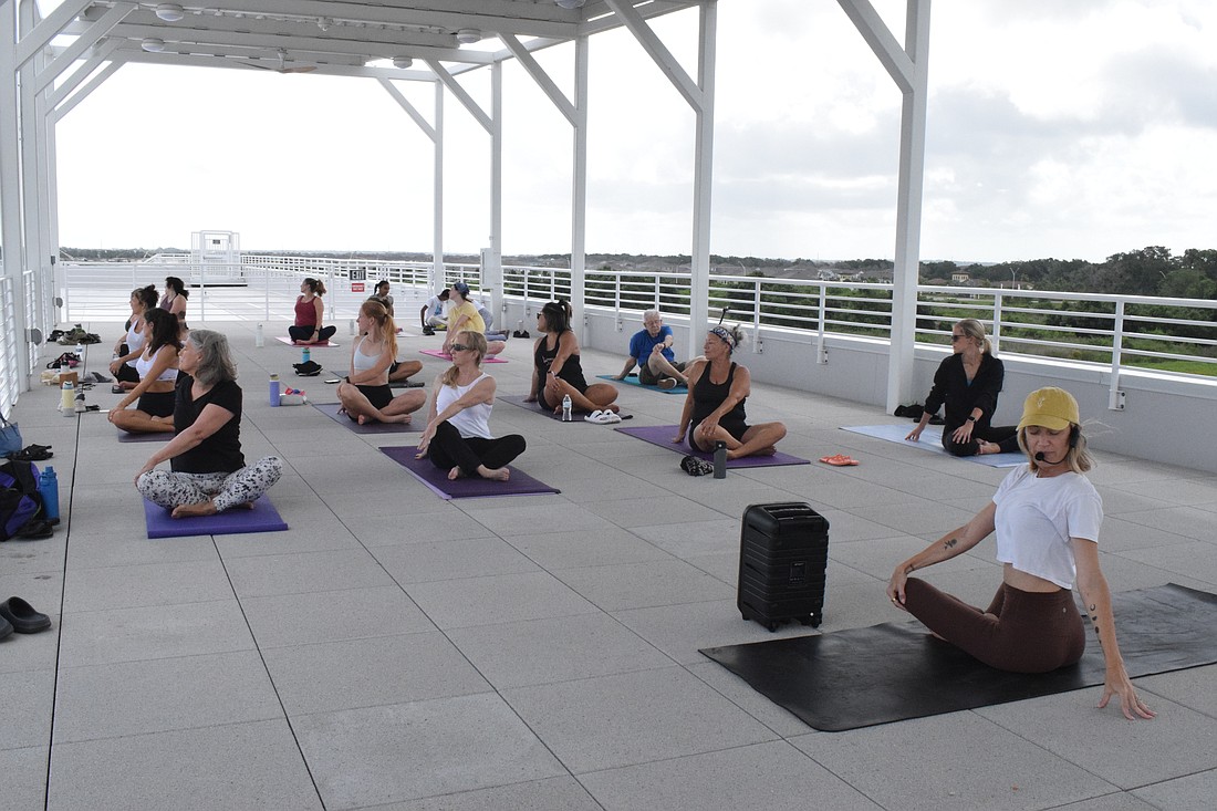Courtenay Smith, an owner of Shack Yoga and a Rooftop Yoga instructor, says she loves the setting of Rooftop Yoga because it allows people to connect with nature as there are nature preserves around the Lakewood Ranch Library.