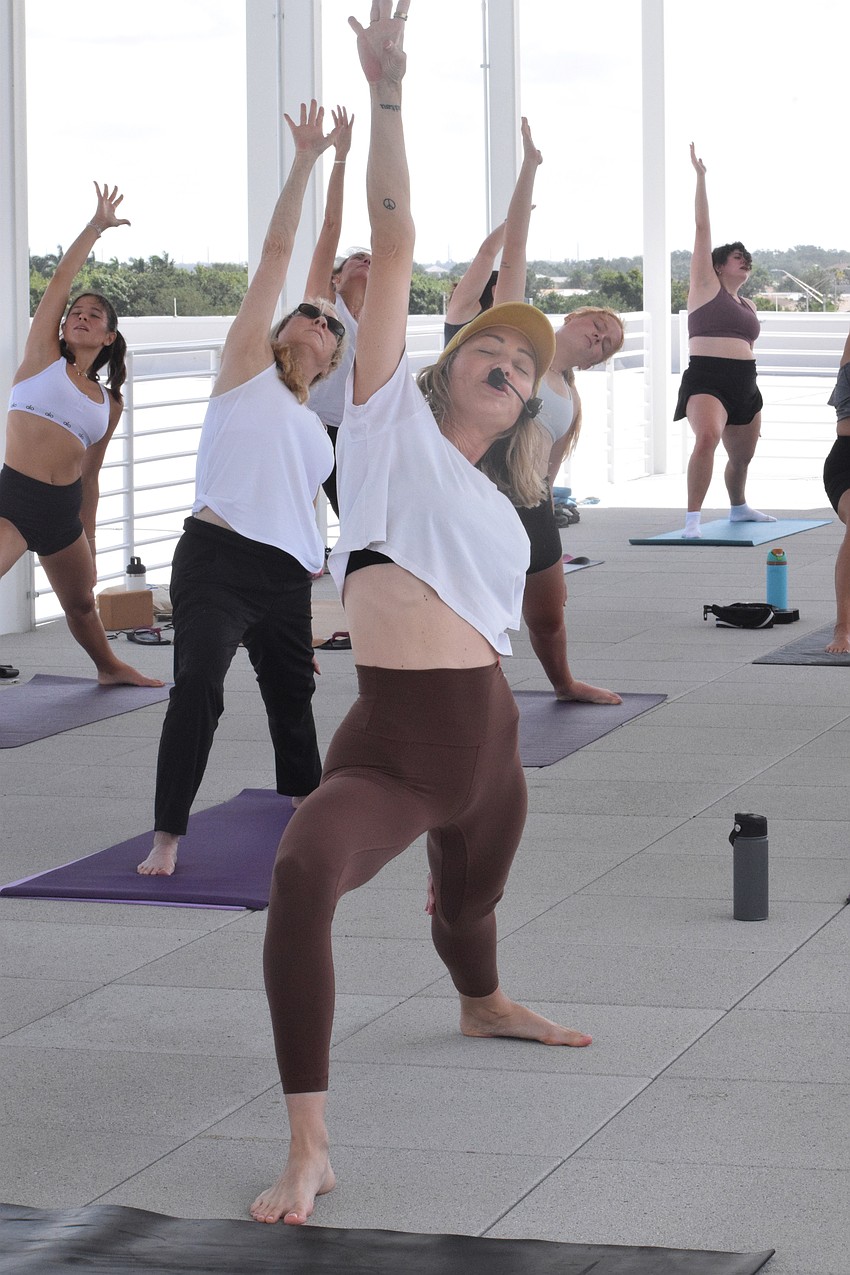 Courtenay Smith, an owner of Shack Yoga, guides 18 people through a yoga class on the rooftop of the Lakewood Ranch Library. 