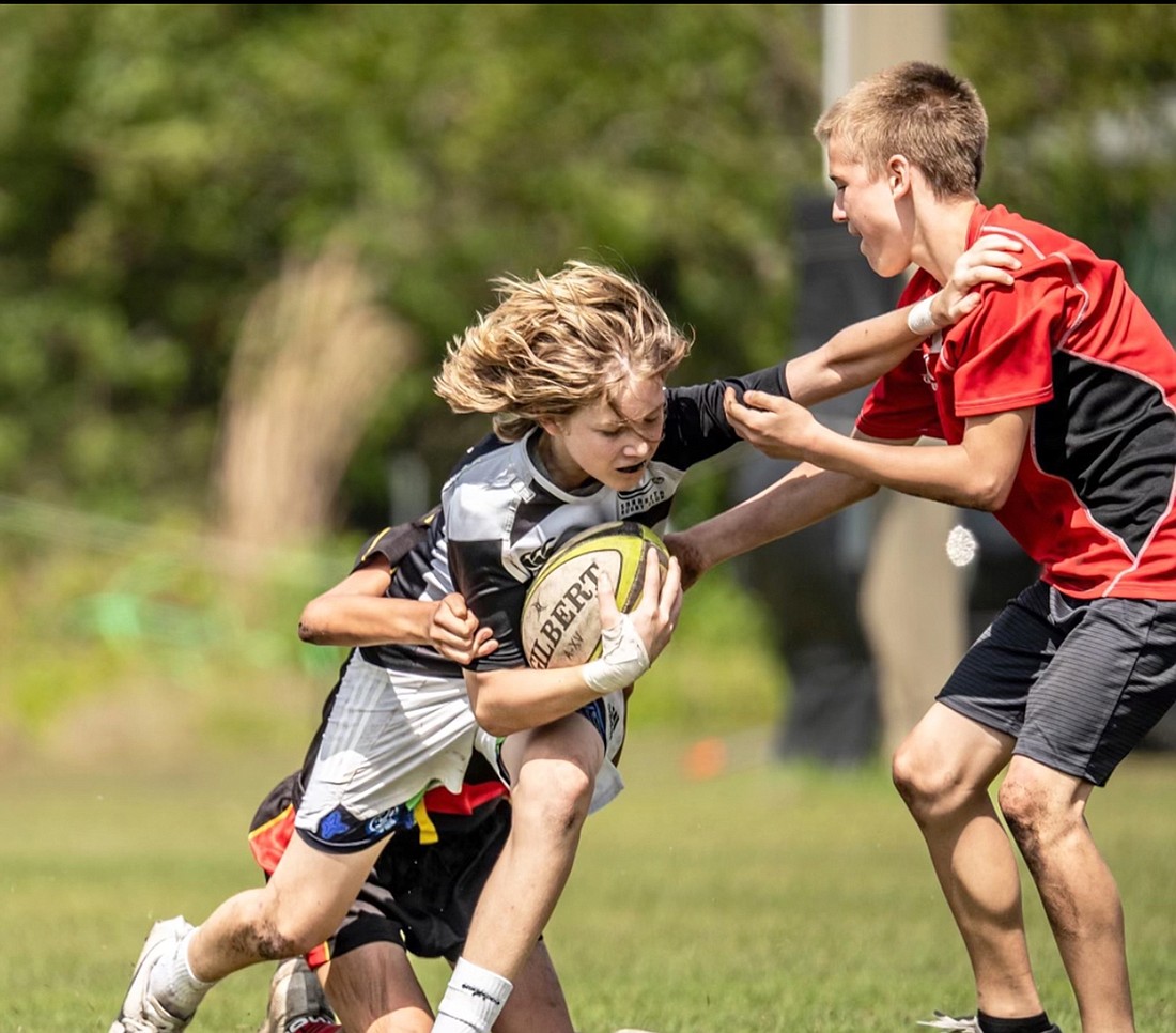 Christian Garzia pushes off defenders during a Sarasota Surge rugby match. Garzia is an advocate of his brother, Rocco, who has Prater-Willi syndrome.