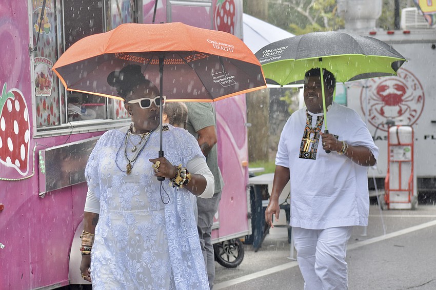 Kesha King and her husband Joe Hokey, two former Sarasota residents from Orlando who love spending time in the area, walk through the event during a downpour of rain.