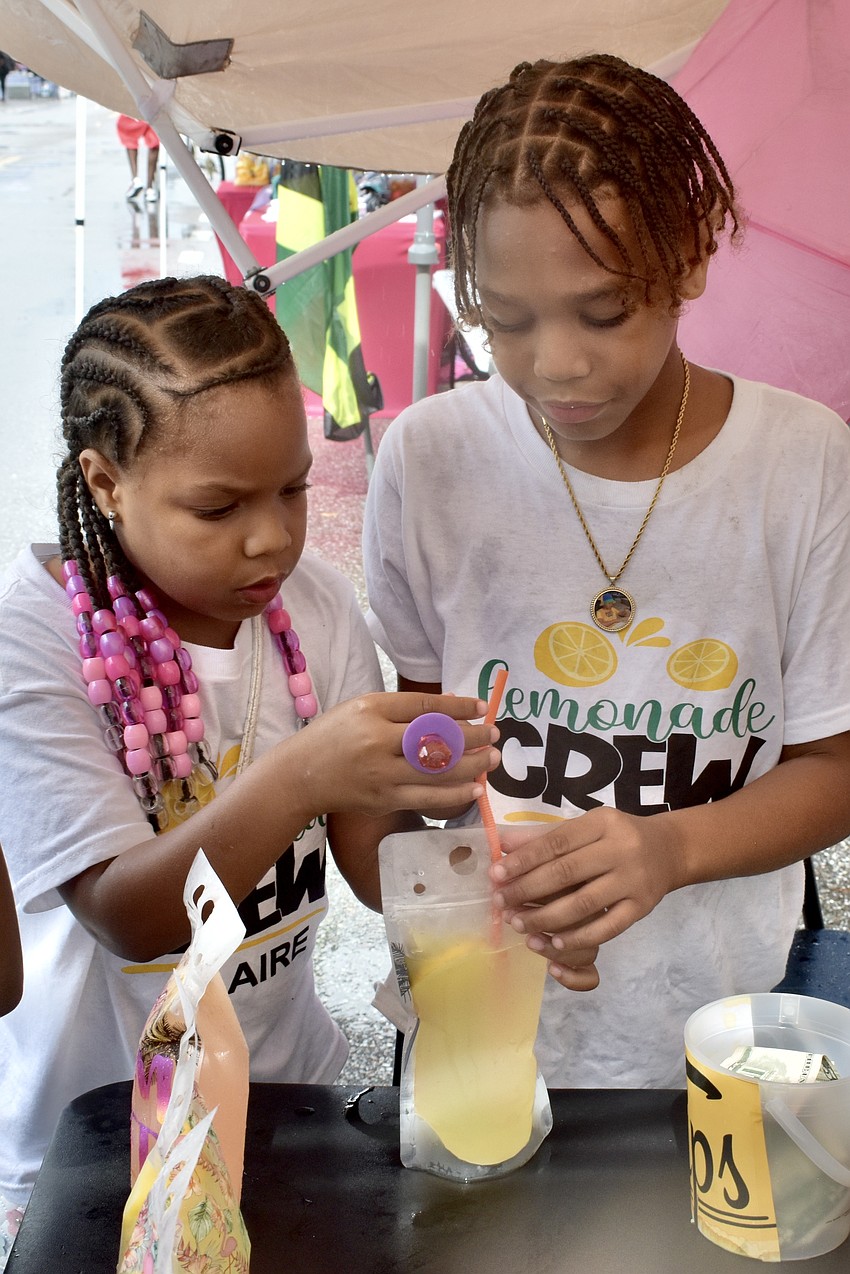 Claire and Clarence Johnson and Naveah Ramos serve as the part of the Lemonade Crew at the Peachz and Kitty's lemonade stand.