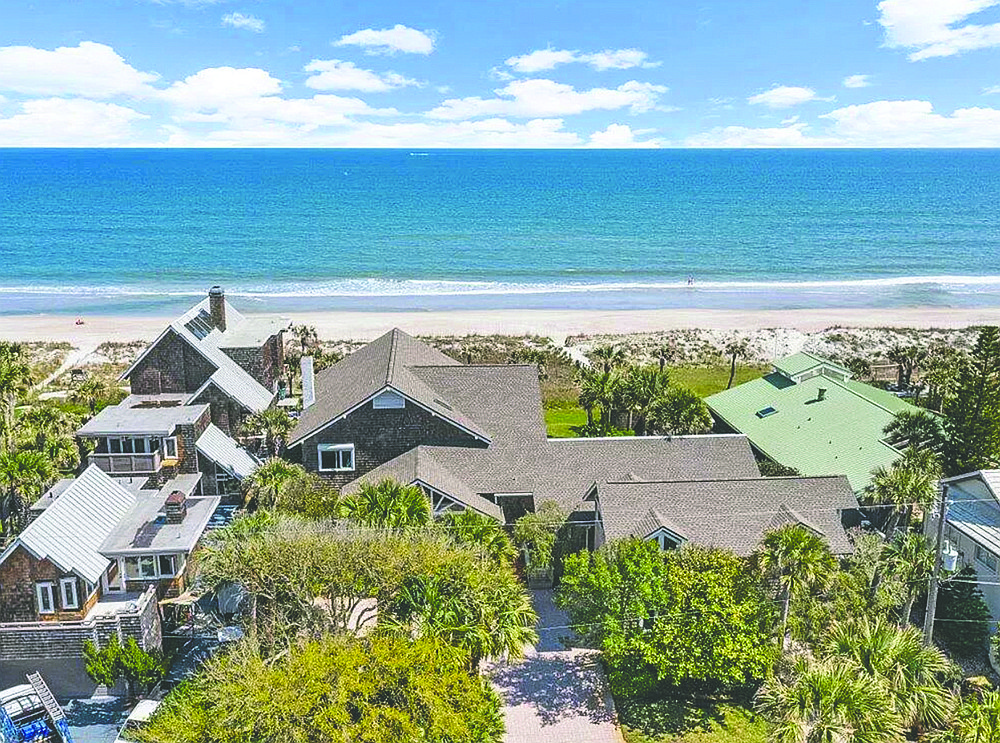 Oceanfront two-story home features eight bedrooms, seven bathrooms, den, library, porches, balcony, deck, pool and guest suite over three-car garage.