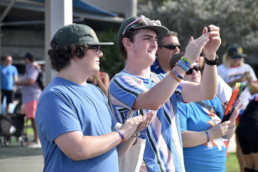 Avery Cole and his brother Kennedy Cole applaud a speaker.