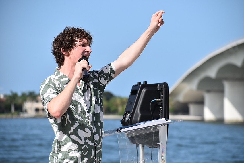 Local activist Zander Moricz leads the crowds in a song, following his speech.