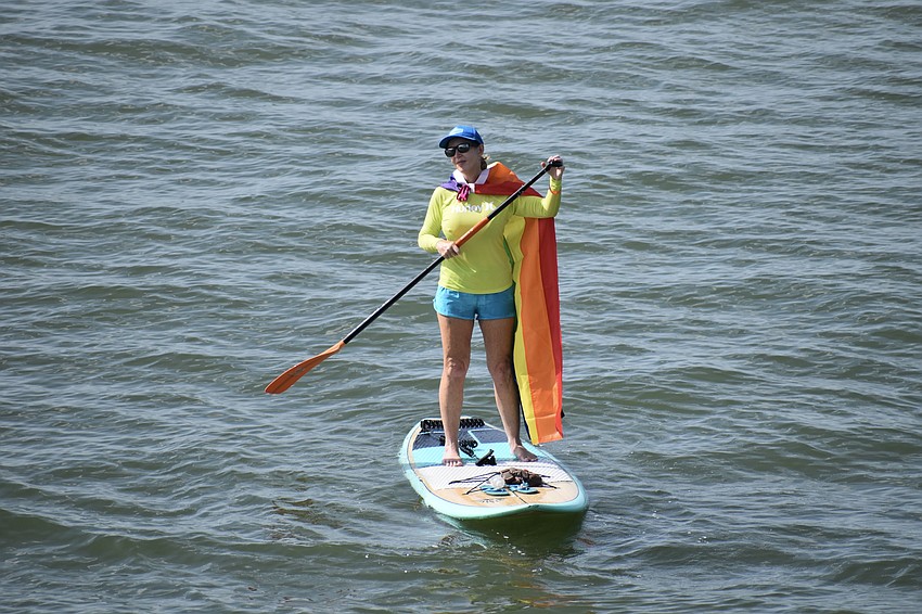 Pediatric psychologist Susan Moschos showed support from beneath the bridge on a paddleboard.