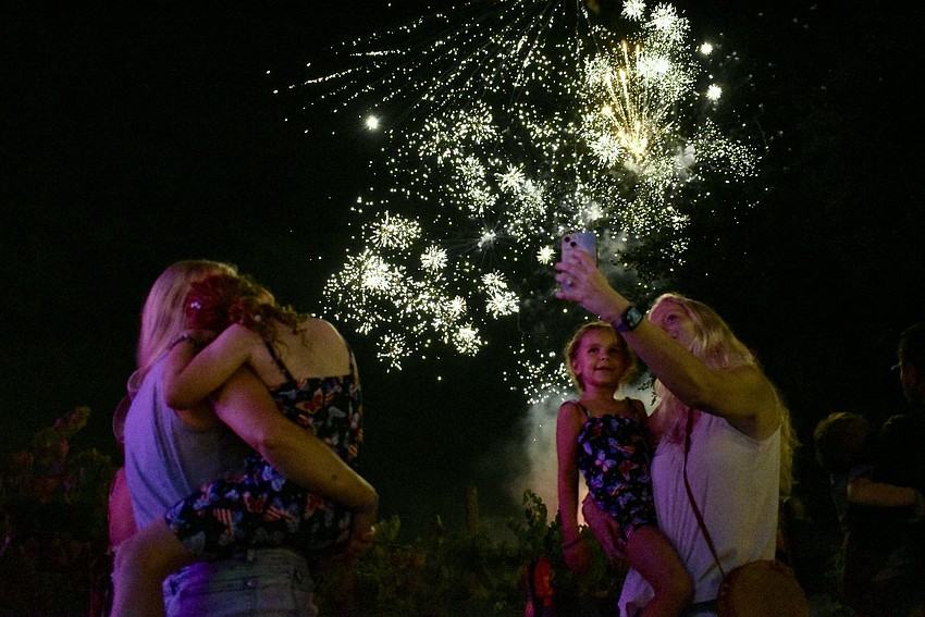 As Courtney Weiland and her 7-year-old daughter Willow watch the fireworks, 5-year-old Brooklyn Cassarino and Susan West take a second to capture the moment.
