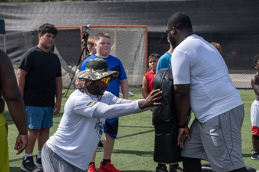 Baraka Atkins and Dumaka Atkins show campers the proper way to burst out of a stance as a lineman.