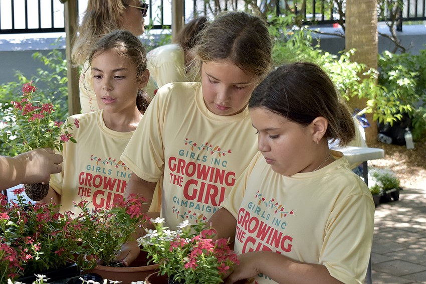 Anastasia V., 8, Penelope O. 9, and Mya R., 8 pot the plants.