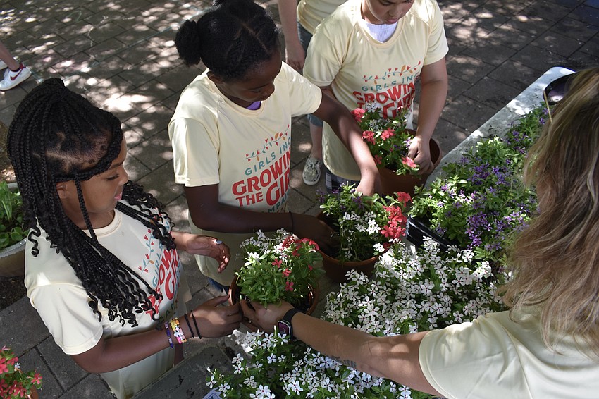 Harmonee E., 11, Ja'Miyah J., 11 and Mariyah B., 11 pot the plants.