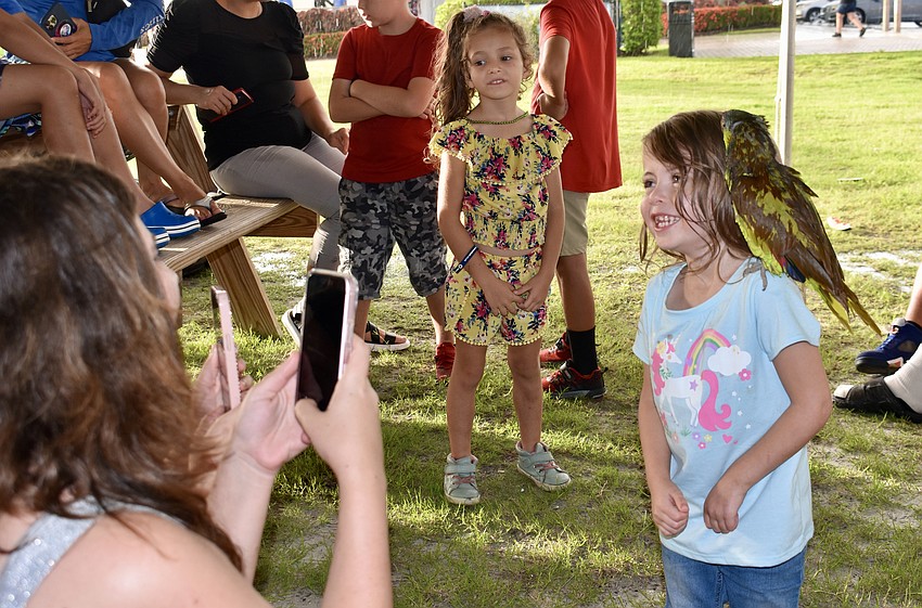 Taco perches on MJ Costanzo's shoulder while mom Danielle takes a photo.