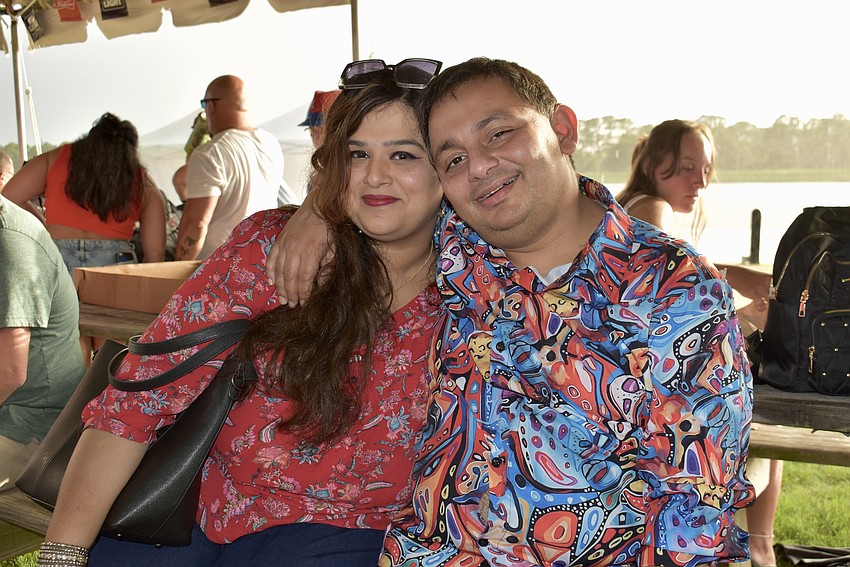 Hafsa Asghar and Ashar Hashimi wait out the rain under a tent.