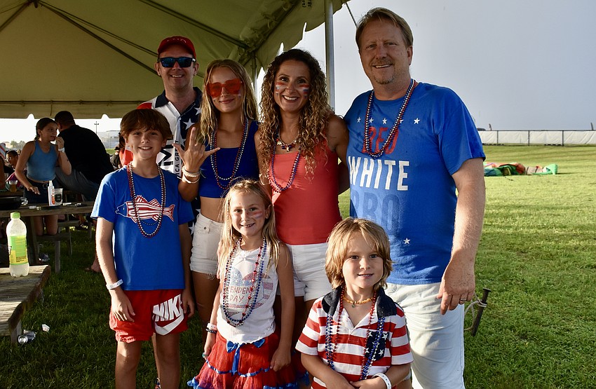 The rain is not dampening the Shepherd family's fun. The kids in the front row are Nicholas, Scarlett and Liam Shepherd. Mark Masingil, Lilliana, Marina and Paul Shepherd stand in the back row.