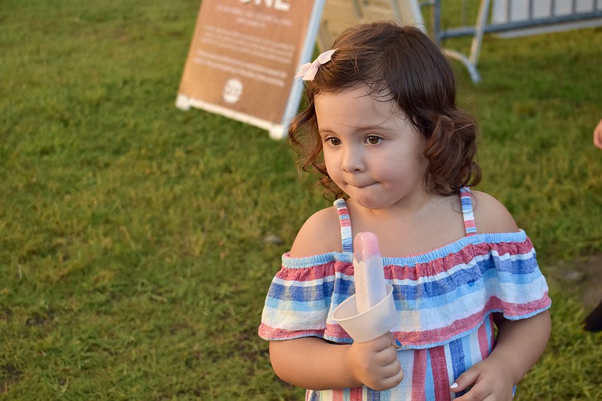 An ice pop helps 3-year-old, DeSoto Lakes resident Alaia Wolford wait patiently to get into the Kids Zone.