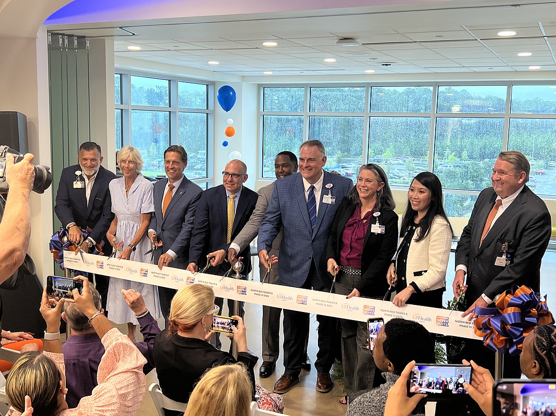 Officials prepare to cut the ribbon at a ceremony for the UF Health North hospital expansion July 8.