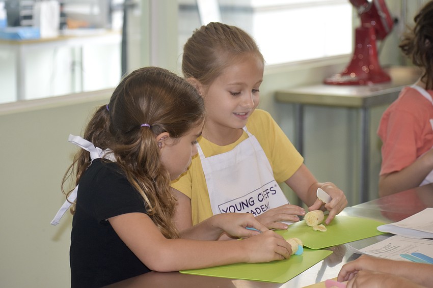 Maddie Ierardi, 7 and Tess Dagotino, 8 slice bananas.