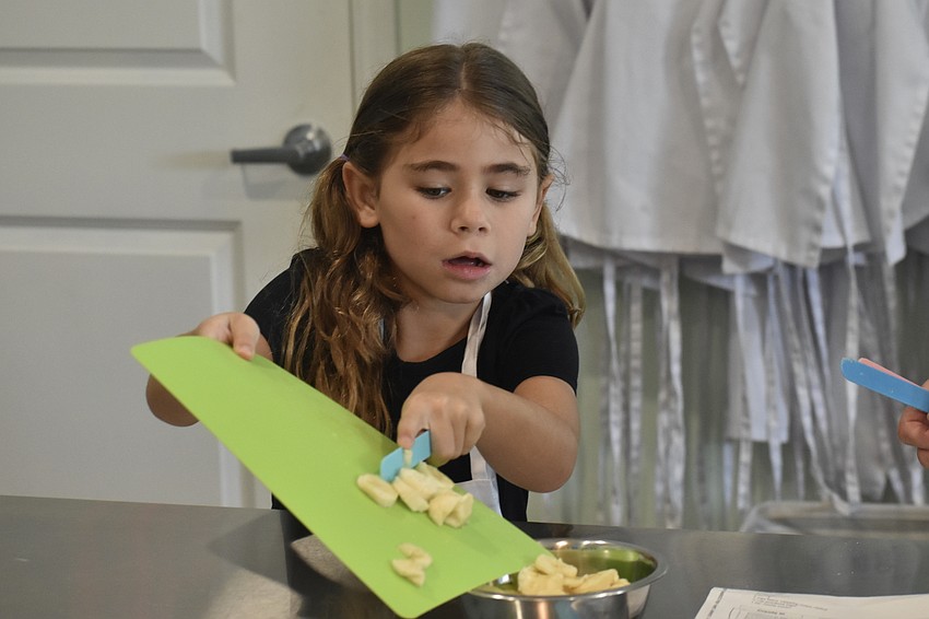 Maddie Ierardi, 7, fills a bowl of banana slices.