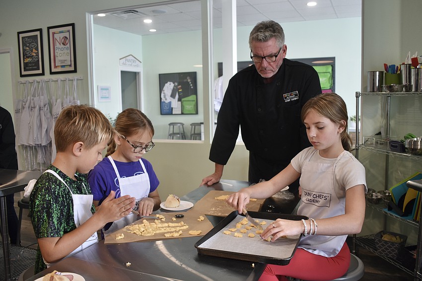 Owen Peacock, 9, Ellie Rodgers, 9, Dennis O'Sullivan and Lillie Olsen, 11, cut out cheese crackers.