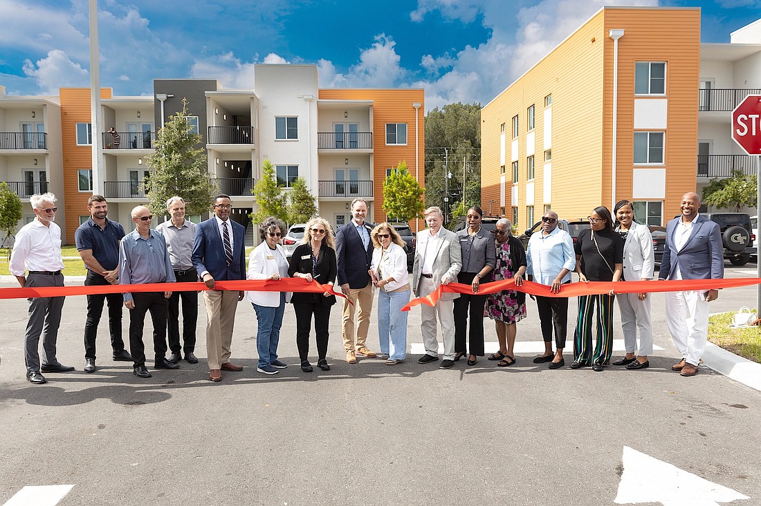 City, county and Sarasota Housing Authority officials snip the ceremonial ribbon to open the SHA's 84-unit Cypress Square apartments.