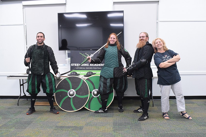 Steel Ring Academy's Chris Fontana, Amanda Closser and Jason Callis join Chris Culp, the youth librarian at Braden River Library, in welcoming children to the academy's live sword fighting demonstration.