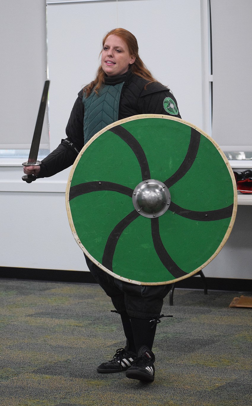 Amanda Closser, the business manager of Steel Ring Academy, shows off the viking sword and shield while sharing the weapons' history.