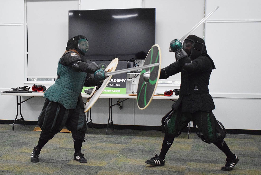 Amanda Closser, the business manager of Steel Ring Academy, yells as she puts all her energy into going after Jason Callis, the owner and founder, with a viking sword and shield.