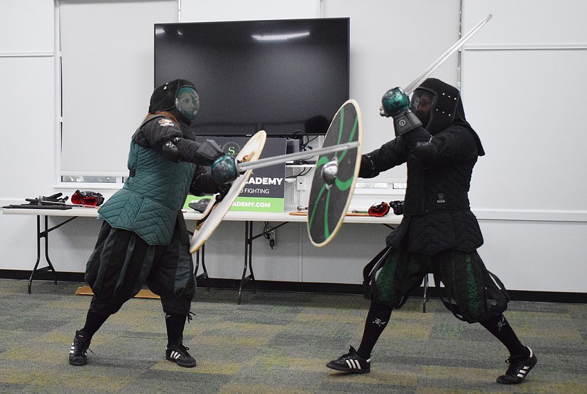 Amanda Closser, the business manager of Steel Ring Academy, yells as she puts all her energy into going after Jason Callis, the owner and founder, with a viking sword and shield.