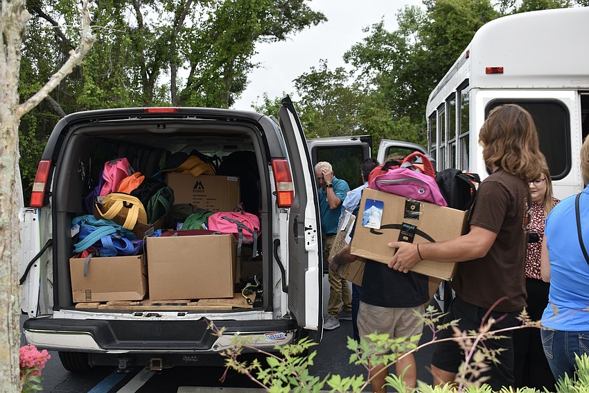 Backpacks stuff the back of a van and a minibus that are heading back to the Boys & Girls Clubs.