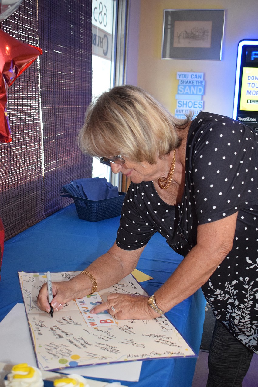 Christina Filkins signing Larry Bateman's goodbye card.